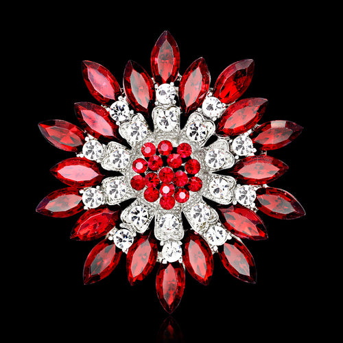 Decorative brooch with red and clear gemstones on a black background