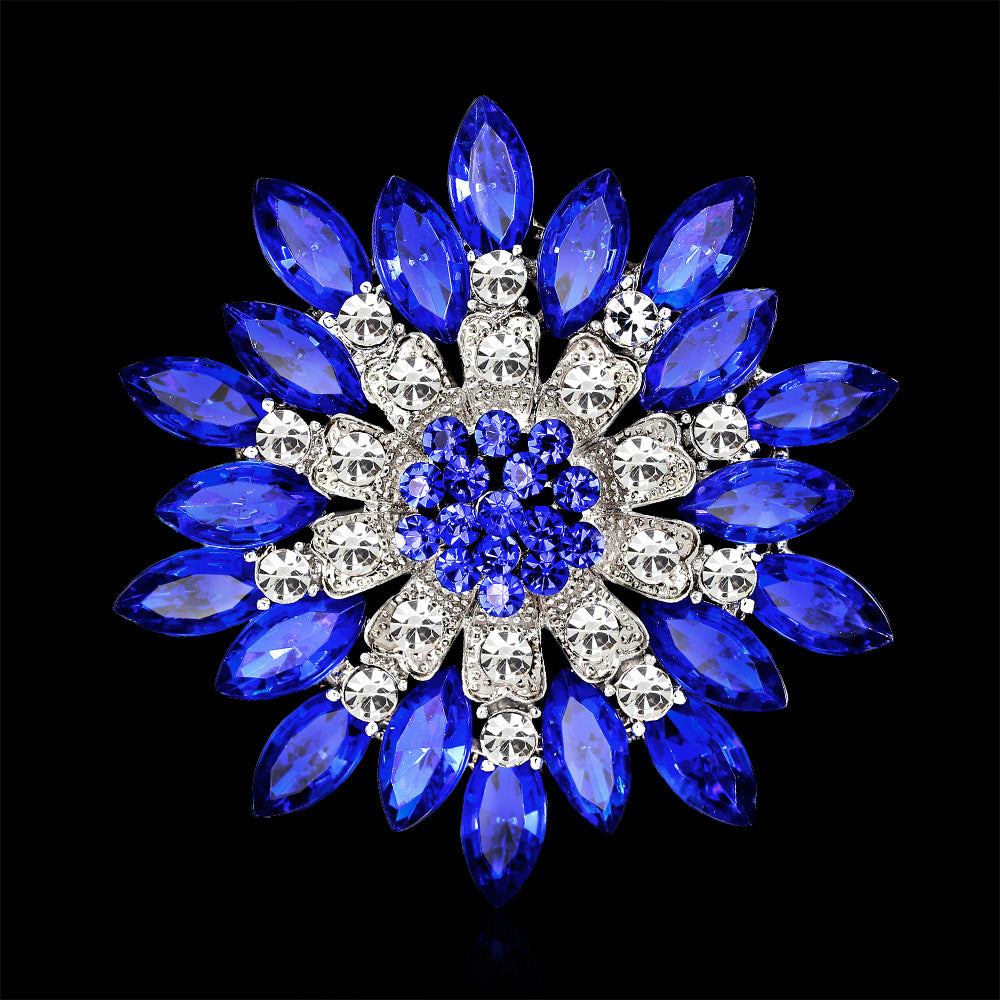 Jewelry brooch with blue and clear gemstones on a black background