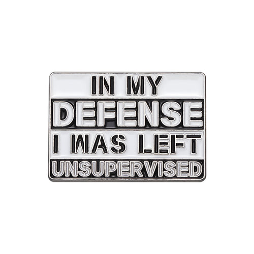 Metallic badge with text 'IN MY DEFENSE I WAS LEFT UNSUPERVISED' on a white background