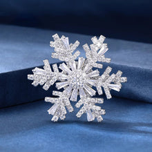 Load image into Gallery viewer, Silver snowflake-shaped brooch on a blue fabric background