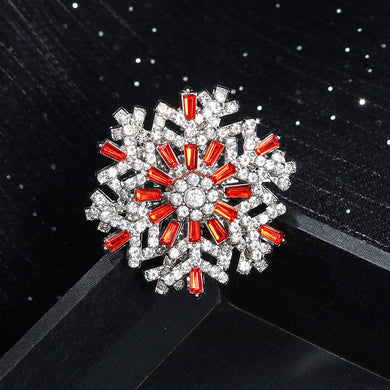 Decorative brooch with red and clear gemstones on a black background