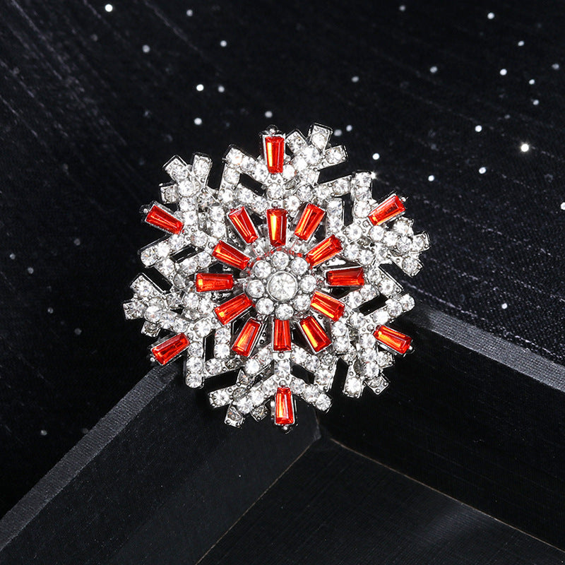 Decorative brooch with red and clear gemstones on a black background