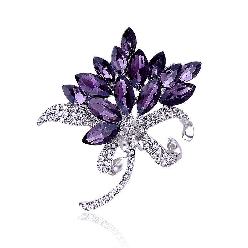 Purple leaf-shaped brooch with clear crystals on a white background