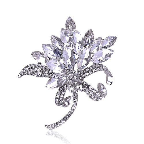 Silver brooch with crystal-like stones on a white background