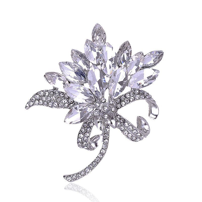 Silver brooch with crystal-like stones on a white background