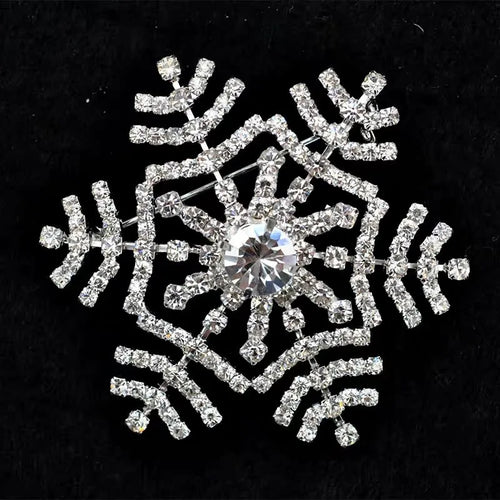 Decorative snowflake brooch with rhinestones on a black background