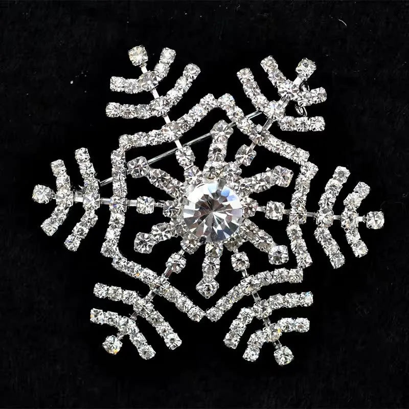 Decorative snowflake brooch with rhinestones on a black background
