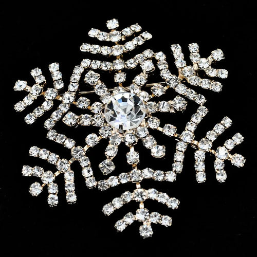 Decorative snowflake brooch with rhinestones on a black background