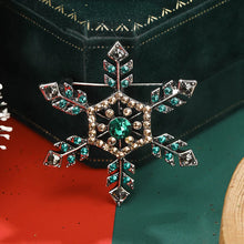 Load image into Gallery viewer, Decorative snowflake brooch with gemstones on a green and red background