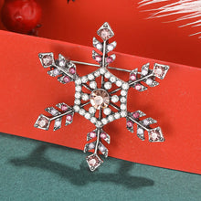 Load image into Gallery viewer, Decorative snowflake brooch with pink and clear gemstones on a red background