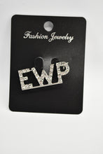 Load image into Gallery viewer, Silver 'EWP' brooch on a black card with brand name