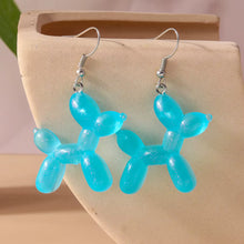 Load image into Gallery viewer, blue balloon dog-shaped earrings on a beige stone surface
