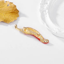 Load image into Gallery viewer, Gold decorative item with red interior on a white surface with a leaf and ceramic plate in the background