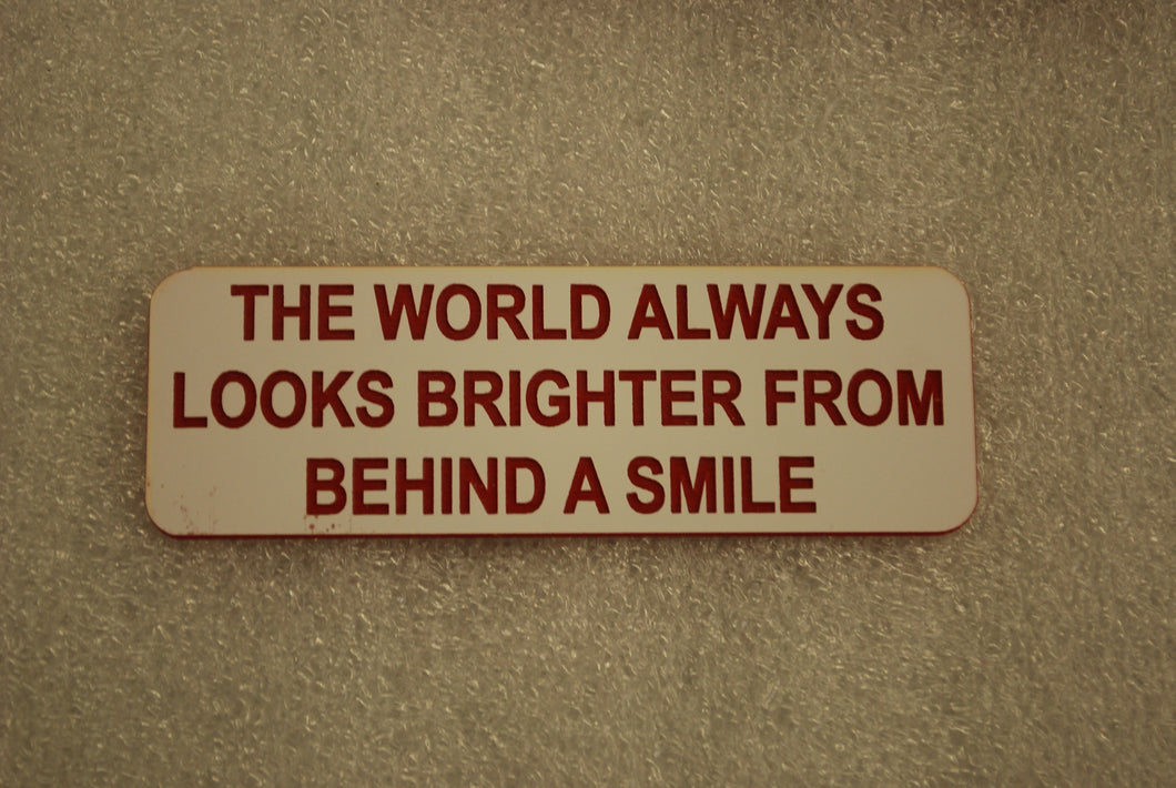 THE WORLD ALWAYS LOOKS BRIGHTER FROM BEHIND A SMILE